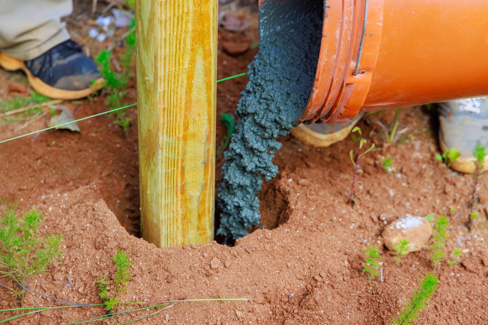 Newly,installed,timber,fencing,wooden,fence,posts,are,poured,with