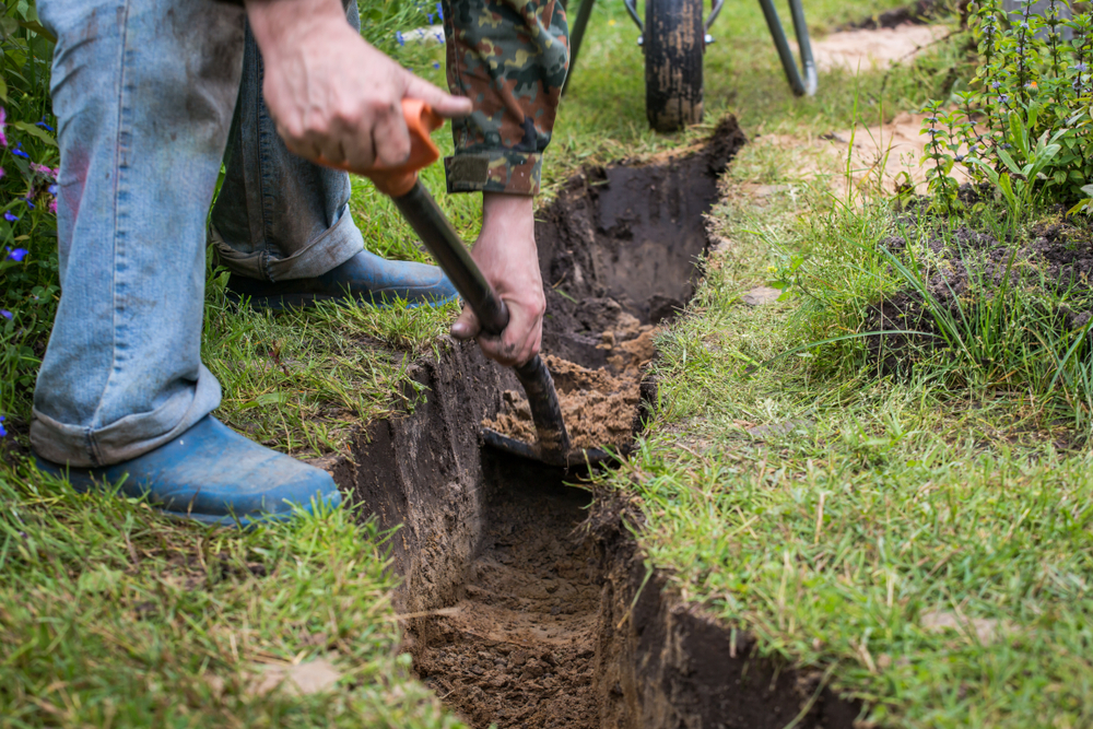 Drainage,ditch.,a,man,is,digging,a,ditch.,laying,a